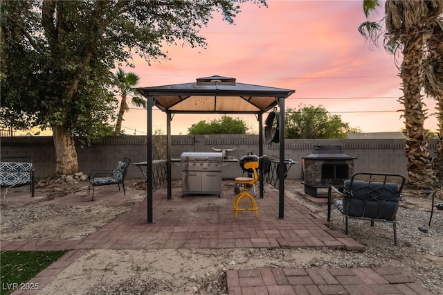 711 Sari Dr, Las Vegas, NV 89110 - fenced backyard with a gazebo, a patio, area for grilling, and an outdoor living space with a fireplace