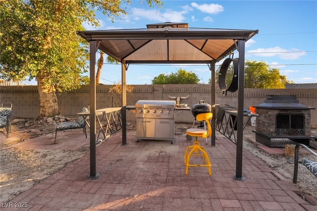 711 Sari Dr, Las Vegas, NV 89110 - fenced backyard with a gazebo, exterior fireplace, and a patio area