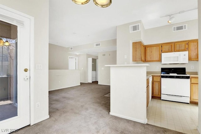 kitchen with visible vents, white appliances, rail lighting, and light colored carpet
