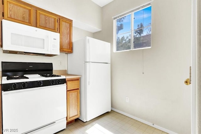 kitchen with baseboards, white appliances, light countertops, and brown cabinets