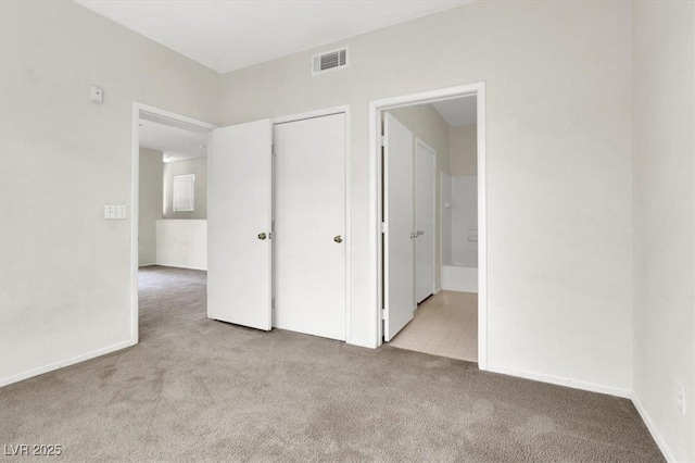 unfurnished bedroom with connected bathroom, a closet, visible vents, and carpet floors