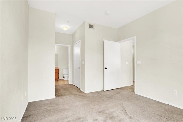 unfurnished bedroom featuring baseboards, visible vents, connected bathroom, and carpet flooring