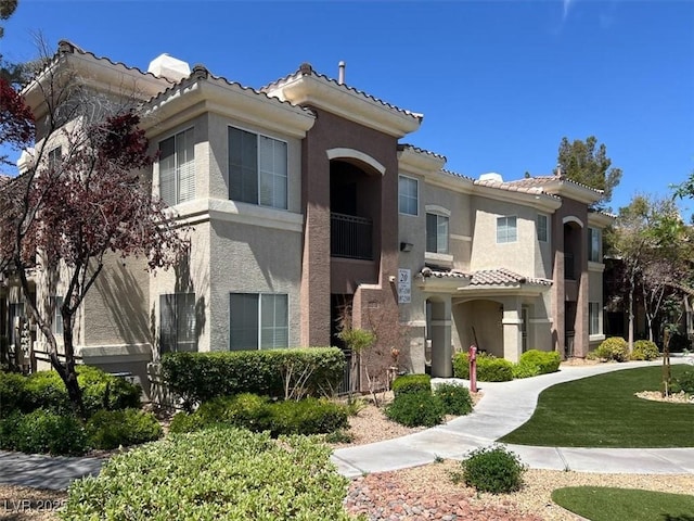 view of front of house with stucco siding and a tile roof