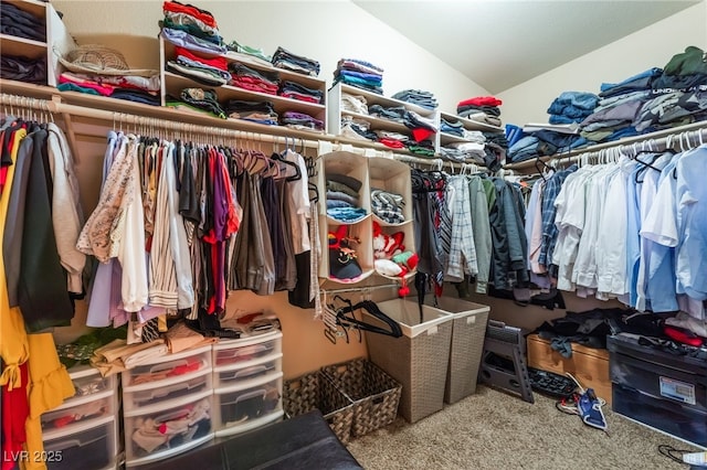 walk in closet with lofted ceiling and carpet