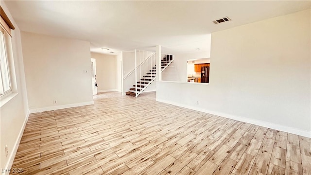 201 Redstone St, Las Vegas, NV 89145 - unfurnished living room featuring light wood finished floors, stairs, visible vents, and baseboards