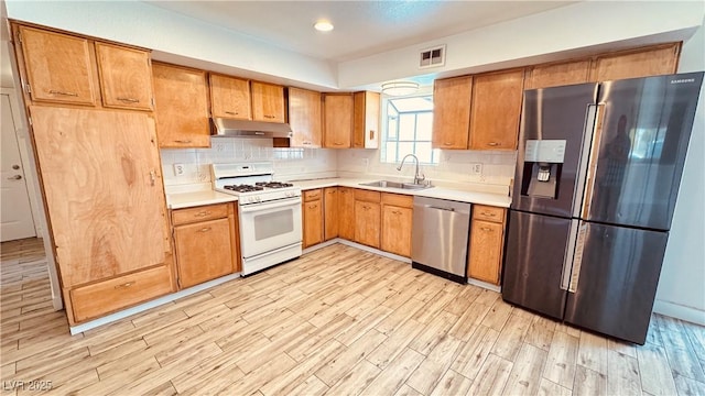 201 Redstone St, Las Vegas, NV 89145 - kitchen featuring a sink, under cabinet range hood, light wood-style floors, visible vents, and appliances with stainless steel finishes