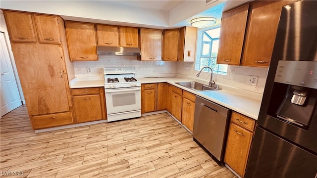 201 Redstone St, Las Vegas, NV 89145 - kitchen with light wood finished floors, a sink, stainless steel appliances, under cabinet range hood, and light countertops