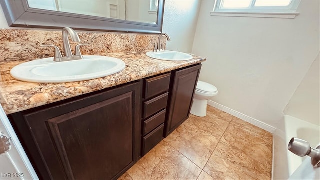 201 Redstone St, Las Vegas, NV 89145 - bathroom featuring toilet, double vanity, a sink, and baseboards