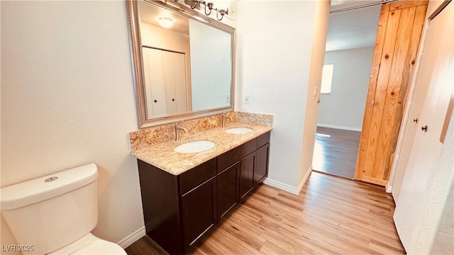201 Redstone St, Las Vegas, NV 89145 - bathroom featuring wood finished floors, toilet, baseboards, and a sink