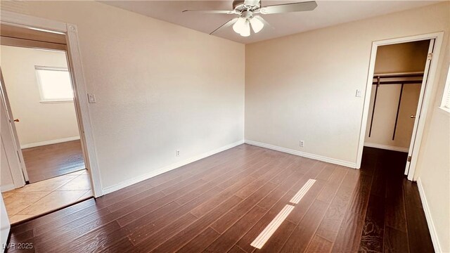 201 Redstone St, Las Vegas, NV 89145 - unfurnished bedroom with a closet, baseboards, wood finished floors, a ceiling fan, and a walk in closet