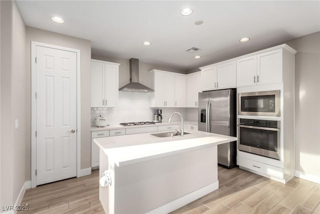 1049 Williamtown Ave, North Las Vegas, NV 89084 - kitchen featuring wall chimney range hood, a sink, stainless steel appliances, light countertops, and light wood-type flooring