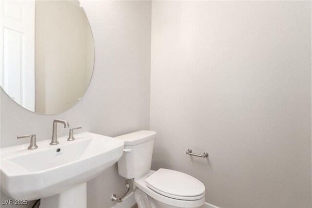 1049 Williamtown Ave, North Las Vegas, NV 89084 - bathroom with baseboards, toilet, and a sink