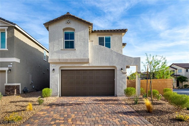 1049 Williamtown Ave, North Las Vegas, NV 89084 - mediterranean / spanish-style house with fence, a tile roof, decorative driveway, stucco siding, and a garage
