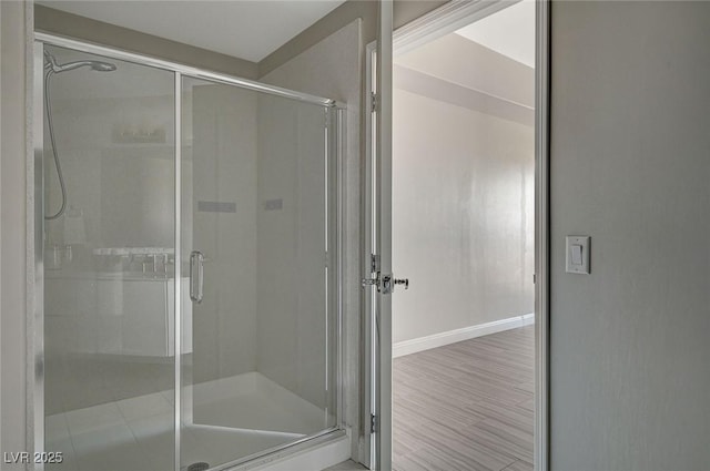 full bathroom featuring a shower stall and baseboards