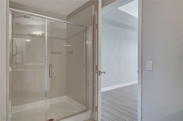bathroom with a stall shower and baseboards