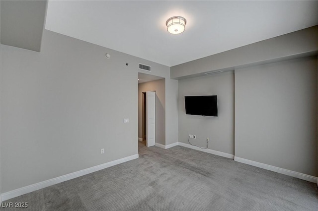 carpeted spare room with visible vents and baseboards