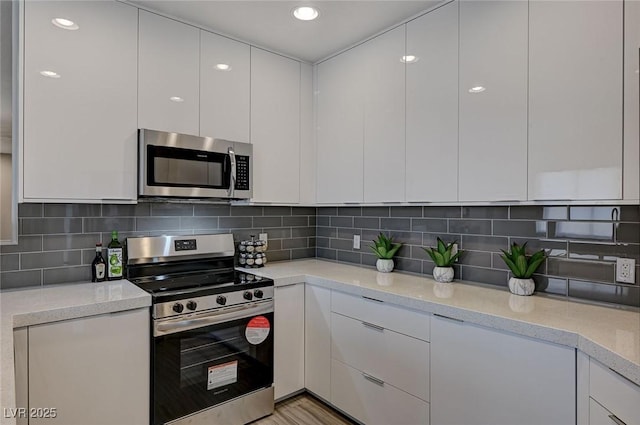 kitchen featuring modern cabinets, white cabinets, and stainless steel appliances