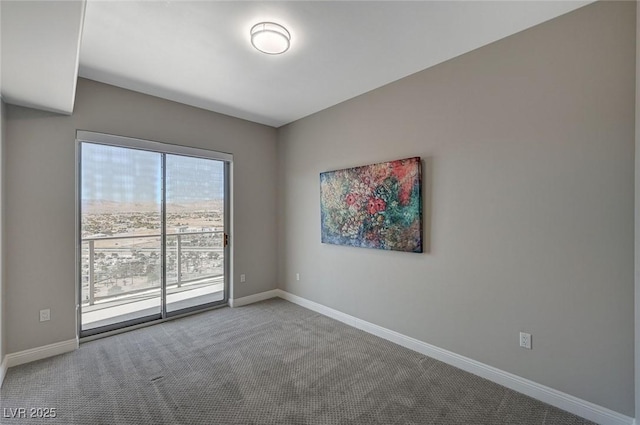 carpeted spare room featuring baseboards