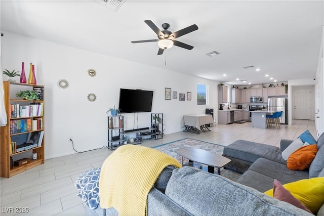 living room featuring recessed lighting, a ceiling fan, and visible vents