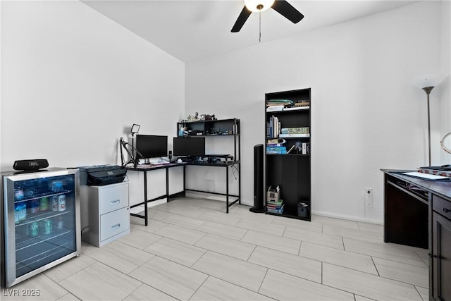 office space with a ceiling fan, baseboards, and beverage cooler