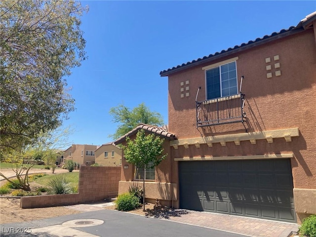 view of front of home with fence, stucco siding, an attached garage, and a tile roof