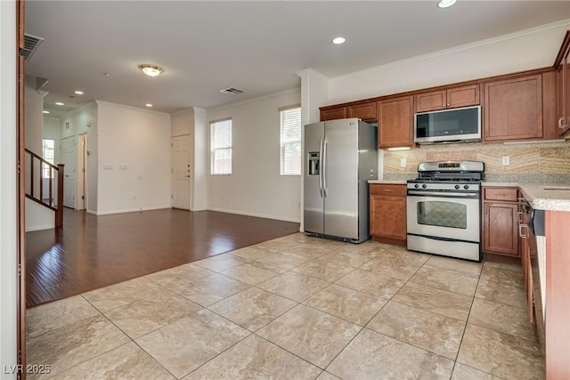 1139 Via Partito, Henderson, NV 89052 - kitchen with appliances with stainless steel finishes, light tile patterned flooring, recessed lighting, crown molding, and tasteful backsplash