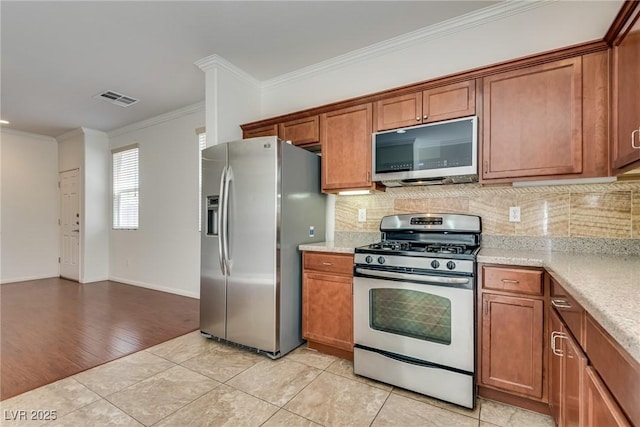 1139 Via Partito, Henderson, NV 89052 - kitchen with appliances with stainless steel finishes, brown cabinets, crown molding, and backsplash