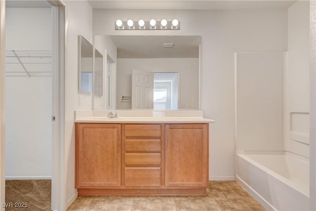 8626 Anderson Dale Ave, Las Vegas, NV 89178 - bathroom featuring vanity, baseboards, bathtub / shower combination, and a walk in closet