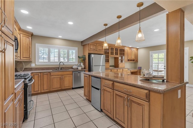 kitchen featuring stone counters, a sink, glass insert cabinets, stainless steel appliances, and recessed lighting
