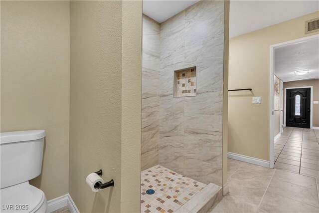 full bath featuring tile patterned floors, baseboards, a stall shower, and toilet