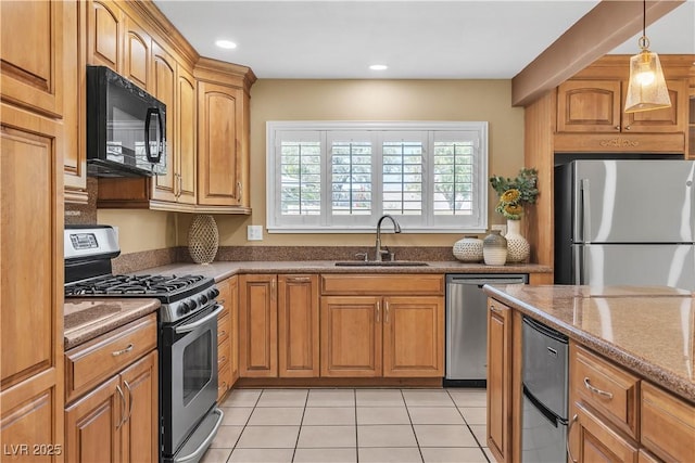 kitchen featuring appliances with stainless steel finishes, a sink, recessed lighting, stone counters, and light tile patterned floors