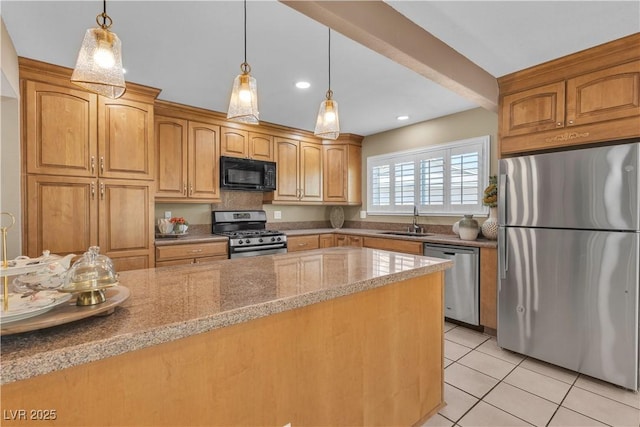 kitchen featuring appliances with stainless steel finishes, hanging light fixtures, a sink, light stone counters, and light tile patterned flooring