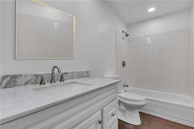 bathroom with vanity, wood finished floors, bathtub / shower combination, and toilet