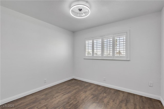 unfurnished room with baseboards and dark wood-style flooring