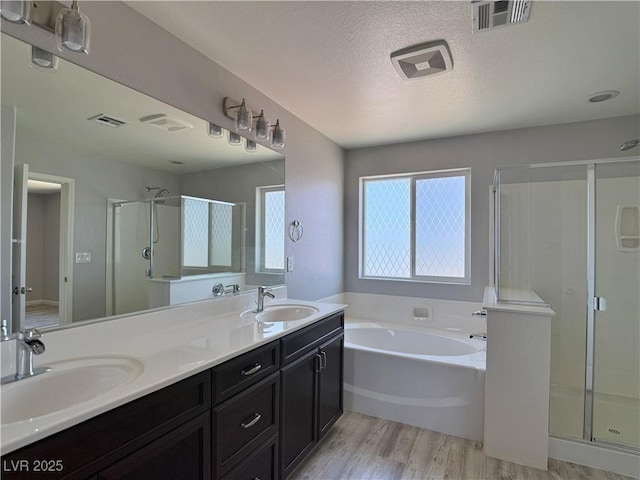 full bath with visible vents, a shower stall, and a sink