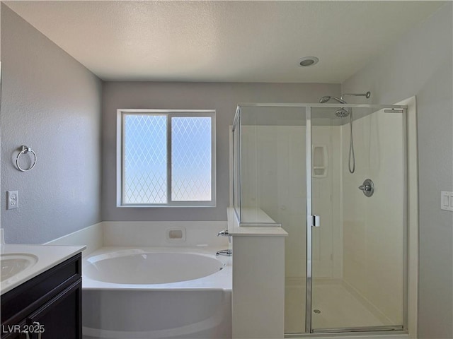 full bathroom featuring a garden tub, a textured ceiling, a stall shower, vanity, and a textured wall