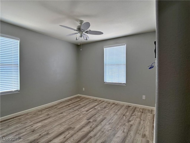 spare room with ceiling fan, baseboards, plenty of natural light, and wood finished floors