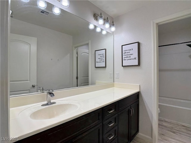 bathroom with vanity, wood finished floors, and visible vents