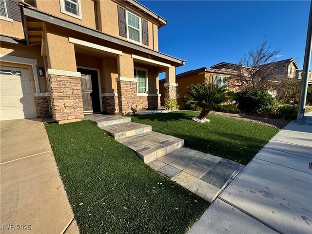 view of front facade with a porch, a front yard, stone siding, and stucco siding