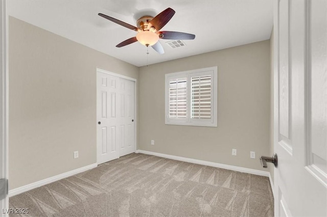 unfurnished bedroom featuring baseboards, a closet, carpet floors, and visible vents