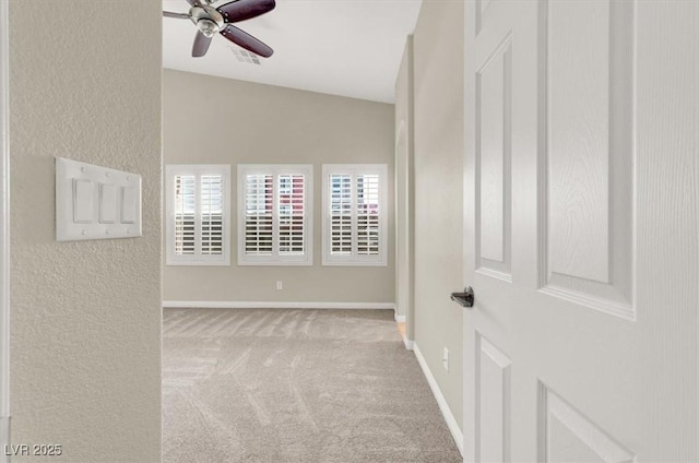 carpeted spare room featuring baseboards, a ceiling fan, a textured wall, and visible vents