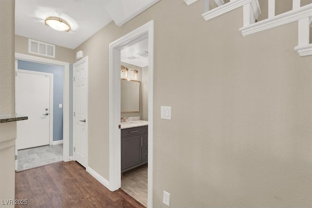hall featuring baseboards, dark wood finished floors, and visible vents