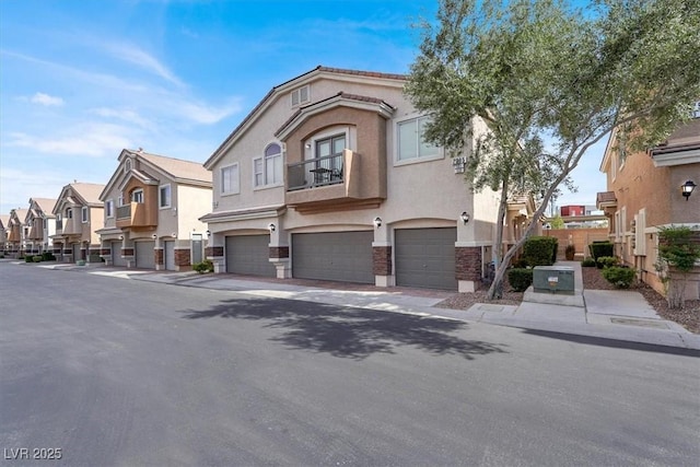 multi unit property featuring a balcony, stone siding, stucco siding, an attached garage, and a residential view