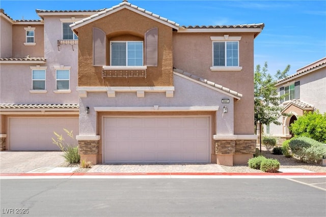 townhome / multi-family property with stucco siding, a tile roof, and stone siding