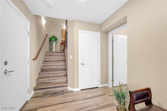 staircase featuring baseboards and wood finished floors