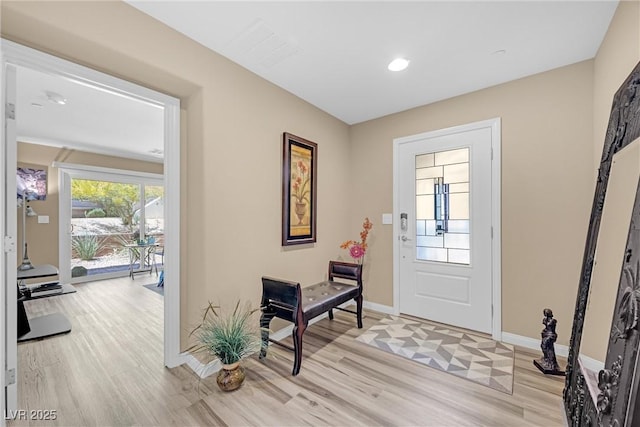 foyer featuring light wood-type flooring, recessed lighting, and baseboards