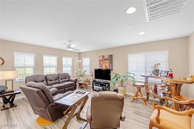 living room featuring a ceiling fan, visible vents, baseboards, light wood-style floors, and recessed lighting