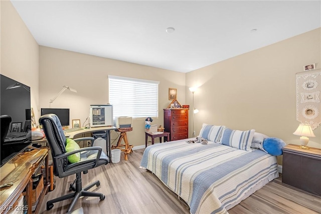 bedroom featuring baseboards and wood finished floors