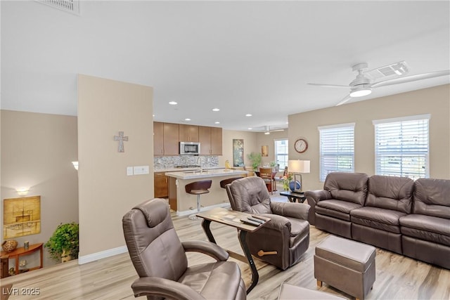 living area featuring recessed lighting, ceiling fan, visible vents, and light wood finished floors