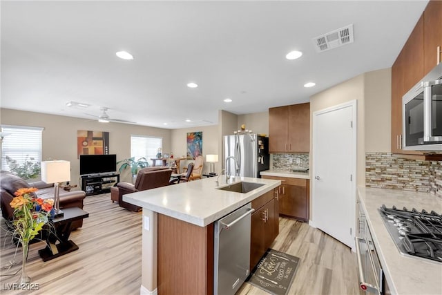kitchen featuring visible vents, light wood-type flooring, light countertops, a sink, and stainless steel appliances